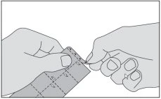 Two hands carefully separating individual tablet blister packs along a perforated dividing line