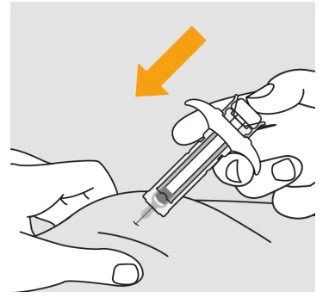A hand holding a syringe at an angle while the