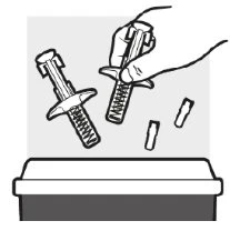 A hand holding a spring-powered medical device above a container as small fragments fall down