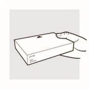 A hand holding a white rectangular box with a black arrow on top indicating its orientation