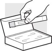 A hand holding a cylindrical container above an open box containing two similar containers placed side by side