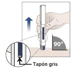 A hand holds an injection pen vertically at a 90-degree angle to the skin, with a magnified inset showing the detail of the lower gray cap