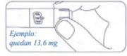A hand holding a medical device with a window displaying the text Ejemplo quedan 13.6 mg on a white background with rounded edges