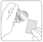 A hand holds a small rectangular device while the