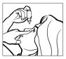 Line drawing showing a hand holding a spray bottle above the open mouth of a person while the
