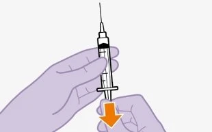 A hand holding a syringe vertically with the needle pointing upward