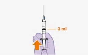 A hand holding a syringe with the needle pointing upward