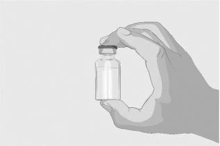 A hand holds vertically a small transparent glass vial with a gray cap on a light neutral background