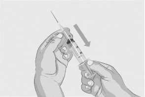 Two hands hold a syringe with the needle pointing downward