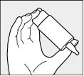 A hand holds a tilted medicine bottle to facilitate dispensing