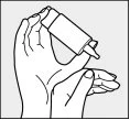 Two hands hold a tilted medicine bottle to let a drop fall into an open palm below