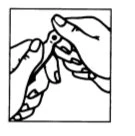 Two hands carefully holding and opening a small container or medication blister pack to remove its contents