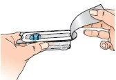 Two hands open a transparent plastic blister pack to remove a blue capsule contained inside
