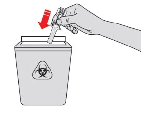A hand inserting a used syringe into a biohazard waste container marked with the biohazard symbol indicated by a red arrow
