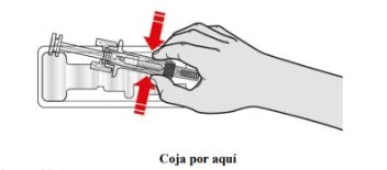 A hand grasping a pre-filled syringe placed on a white background, with two red arrows indicating the correct grip point