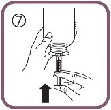 A hand holding a vial while the