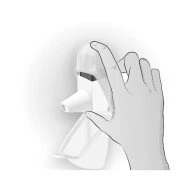 A hand holds a white medical device with a protective cap and a contoured base for drug administration