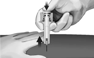 A hand pressing downward on the top of a medical device to insert medication