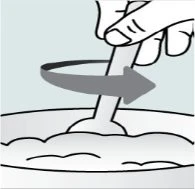 Una mano ruota un bastoncino all'interno di un contenitore con una sostanza semiliquida seguendo il movimento indicato da una freccia curva