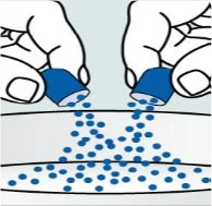 Two hands holding two blue vials to pour small blue spherical particles