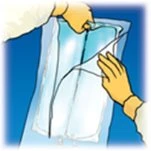 Due mani aprono con attenzione una busta di plastica trasparente contenente un dispositivo medico su sfondo blu scuro