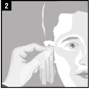 A hand holds a medicine vial close to the