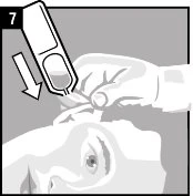 A hand presses a white medical device against the upper cheek of a person following the direction of a white arrow