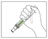 A hand firmly holds a pen-shaped medical device containing green liquid inside the