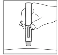 Una mano tiene verticalmente una penna iniettiva medica con un indicatore trasparente sopra una superficie curva chiara