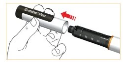 Рука держит верхнюю часть инъекционной ручки O-mine Pen, чтобы вставить её в корпус устройства, что указано красной стрелкой