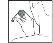 A hand holds an open cylindrical container near a person's face for the