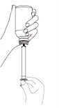 A hand holding a glass vial while the
