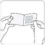 Two hands unfolding and opening a folded instruction leaflet to read the inner content