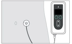 Rectangular medical device with display and control buttons connected by a cable to a circular sensor with a droplet