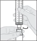 A hand holds a graduated syringe while the