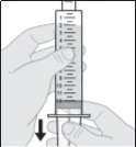 A hand holds a graduated syringe vertically while the