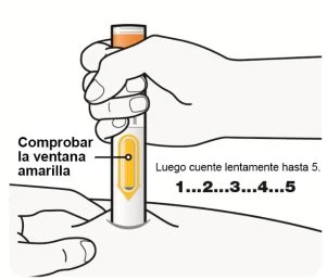 Ręka trzyma pensetę iniekcyjną przyłożoną do skóry z widocznym żółtym okienkiem i napisem „liczyć powoli do 5”