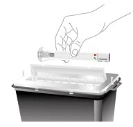 Una mano tiene una siringa orizzontale sopra un contenitore di smaltimento per rifiuti medici di colore scuro con coperchio bianco aperto