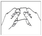 Two hands carefully holding and opening a pouch or small rectangular package to remove its contents