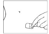 One hand holding a small rectangular object and bringing it close to the skin of the