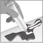A hand squeezes a tube to apply a creamy substance onto an irritated or damaged area of skin