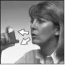 Woman holding an inhaler near her mouth with two white arrows indicating the direction of airflow