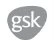 Logo aziendale GSK scritto in lettere minuscole bianche all'interno di una forma irregolare grigia su sfondo bianco