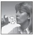 Donna che tiene un inalatore vicino alla bocca con due frecce bianche che indicano il movimento del dispositivo verso l'apertura orale