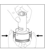 Two hands holding a cylindrical medical device with black arrows indicating a pressing motion toward the center of the body of the