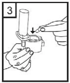A hand inserts a small cylindrical component into a medical device while the