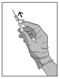 A gloved hand holds a syringe with the needle pointing upward