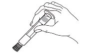 One hand holding an injection pen at an angle to prepare the