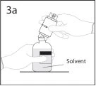 Рука держит ампулу, перевернутую над флаконом с растворителем, чтобы приступить к смешиванию лекарственного препарата