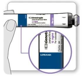 Una mano tiene una siringa di Genotropin da 12 mg con un ingrandimento che mostra l'etichetta con il campo per il numero di lotto